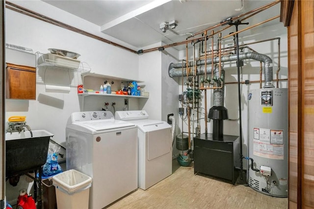 laundry room featuring sink, gas water heater, light hardwood / wood-style flooring, and washing machine and clothes dryer