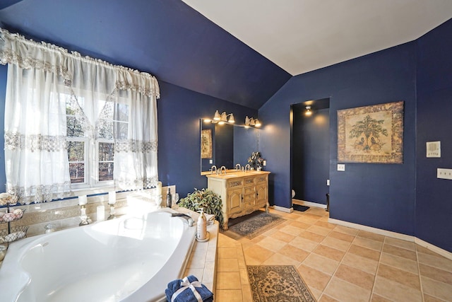 bathroom featuring tile patterned floors, vanity, lofted ceiling, and tiled bath