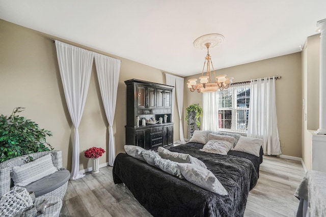 bedroom featuring an inviting chandelier and light wood-type flooring