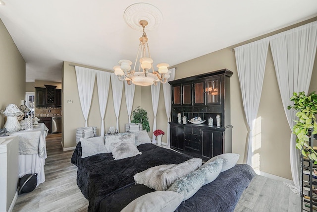 bedroom with a notable chandelier and light wood-type flooring