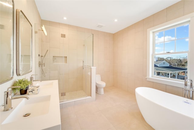 full bathroom featuring tile walls, toilet, tile patterned floors, vanity, and plus walk in shower