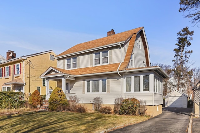 view of front of home featuring a garage, an outdoor structure, and a front lawn