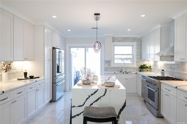 kitchen with wall chimney exhaust hood, stainless steel appliances, sink, pendant lighting, and white cabinets