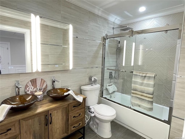 full bathroom featuring vanity, crown molding, tile walls, enclosed tub / shower combo, and tile patterned flooring