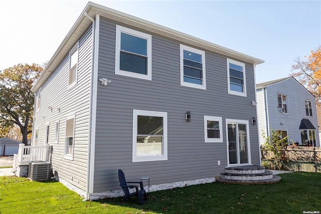 back of house featuring a lawn and central AC unit