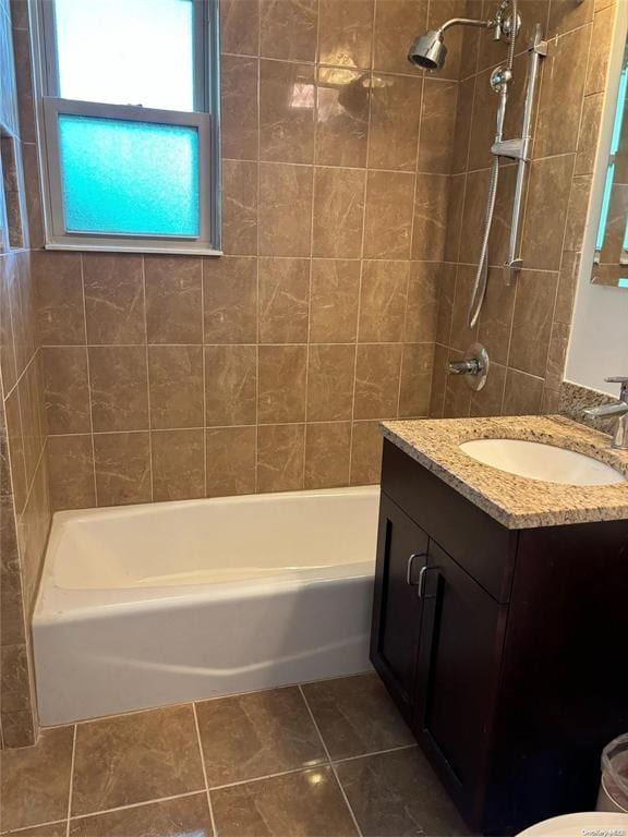 bathroom with tile patterned floors, vanity, and tiled shower / bath