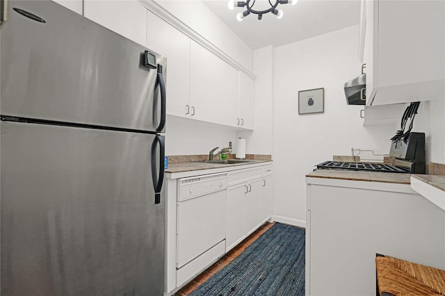 kitchen featuring stainless steel refrigerator, white cabinetry, sink, dark wood-type flooring, and white dishwasher