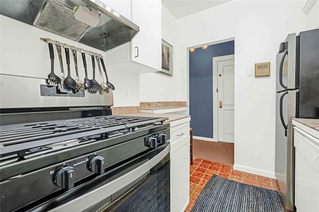 kitchen with stainless steel range with gas cooktop, white cabinetry, range hood, and fridge