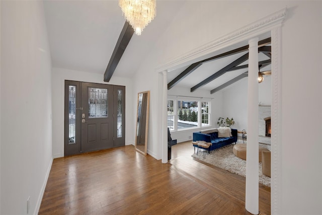 entryway featuring hardwood / wood-style floors, lofted ceiling with beams, and a notable chandelier