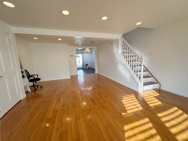 unfurnished living room featuring a chandelier and hardwood / wood-style floors