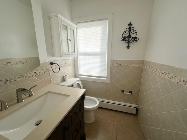 bathroom featuring tile patterned floors, vanity, a baseboard heating unit, tile walls, and toilet