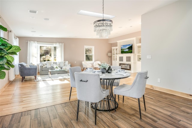 dining area with hardwood / wood-style floors and a chandelier