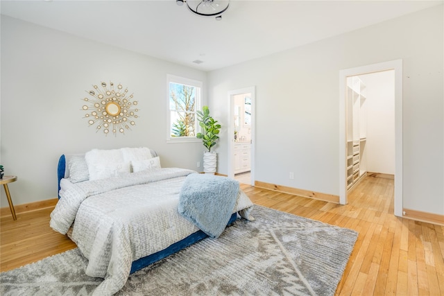 bedroom with ensuite bathroom and wood-type flooring