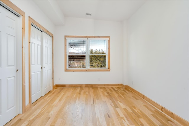 unfurnished bedroom with light wood-type flooring and a closet