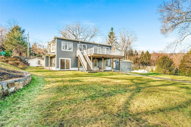 rear view of property with an outbuilding, a yard, and a deck