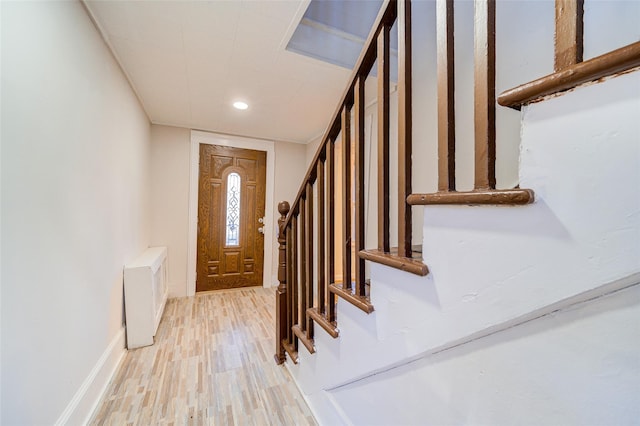 foyer entrance with radiator and hardwood / wood-style floors