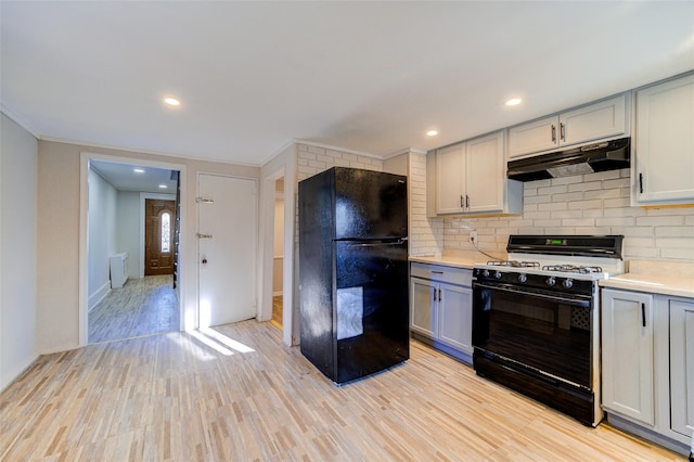 kitchen featuring gray cabinetry, black appliances, ornamental molding, tasteful backsplash, and light hardwood / wood-style floors