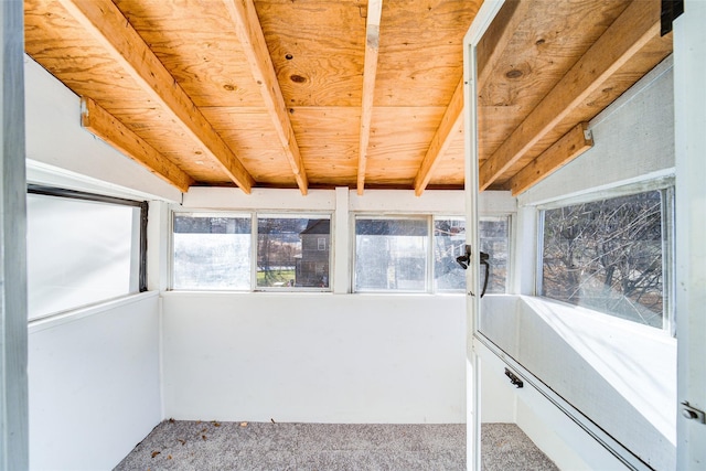 unfurnished sunroom featuring beamed ceiling and wood ceiling