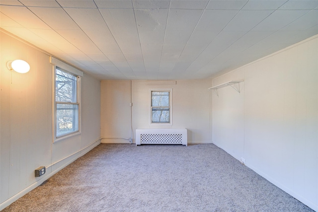 spare room featuring carpet flooring, radiator, and crown molding