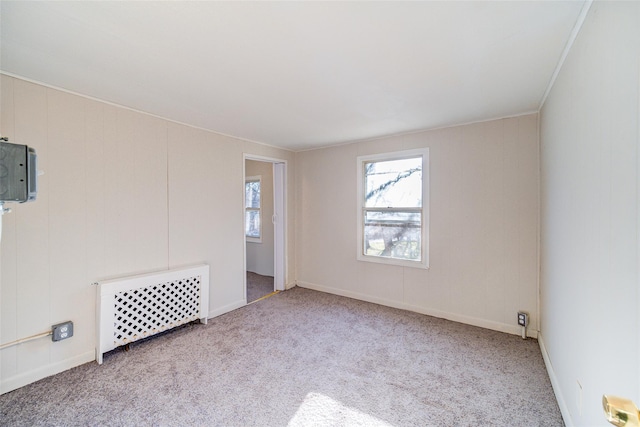 unfurnished room featuring light colored carpet, ornamental molding, and radiator