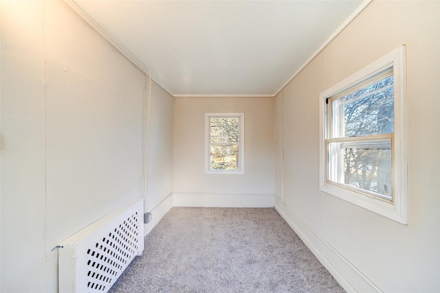 unfurnished room with radiator, light carpet, and crown molding