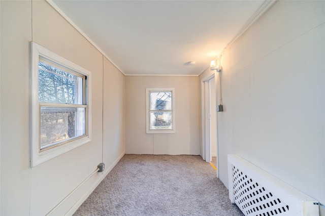 carpeted empty room with radiator heating unit and ornamental molding