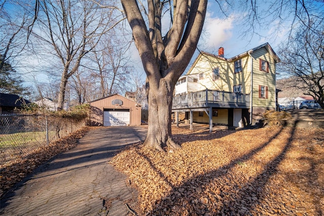 view of front of home featuring a garage, an outdoor structure, and a wooden deck