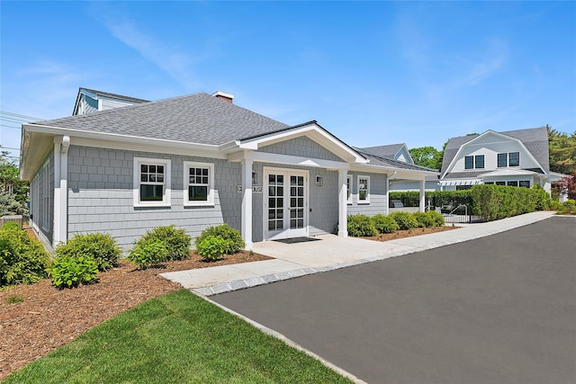 12 Depot Road 1302 (Pearl Way), Westhampton Beach, NY 11978 - view of front facade featuring a shingled roof and a chimney