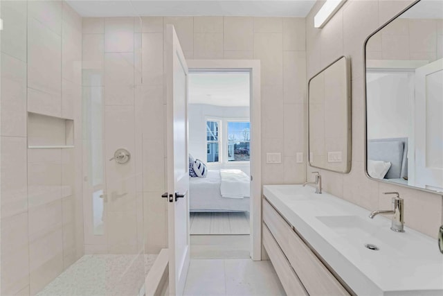 12 Depot Road 1302 (Pearl Way), Westhampton Beach, NY 11978 - ensuite bathroom featuring double vanity, tiled shower, tile walls, and tile patterned floors