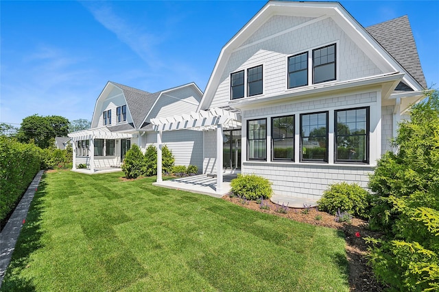 12 Depot Road 1302 (Pearl Way), Westhampton Beach, NY 11978 - back of property with a pergola, a shingled roof, a patio area, and a lawn