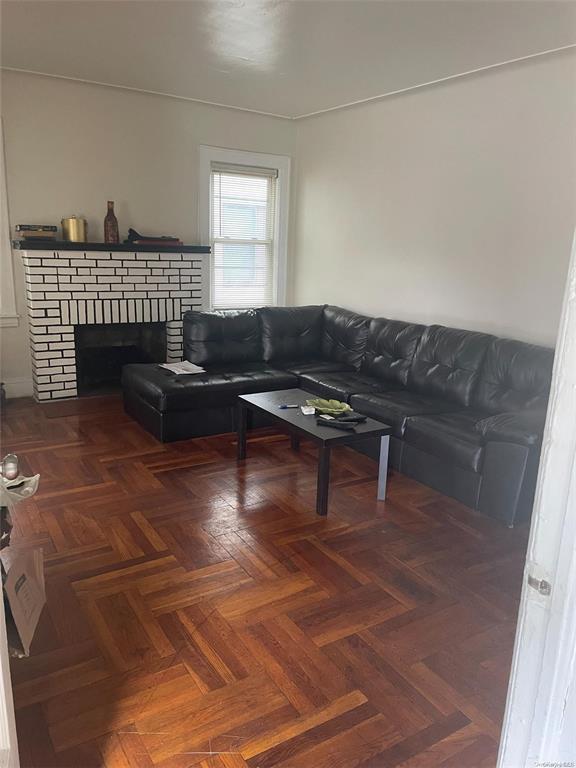 living room featuring a fireplace and dark parquet floors