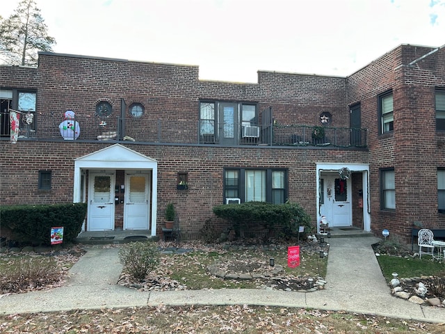 townhome / multi-family property with french doors, a balcony, and cooling unit