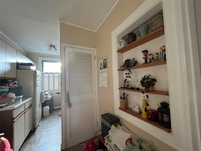 hallway featuring crown molding, light tile patterned floors, and radiator heating unit