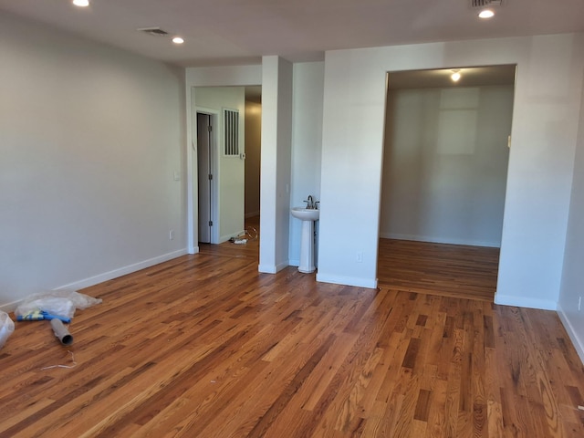 empty room featuring hardwood / wood-style flooring and sink