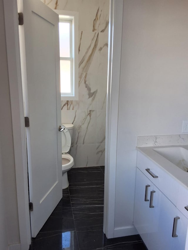 bathroom with toilet, vanity, and tile patterned floors