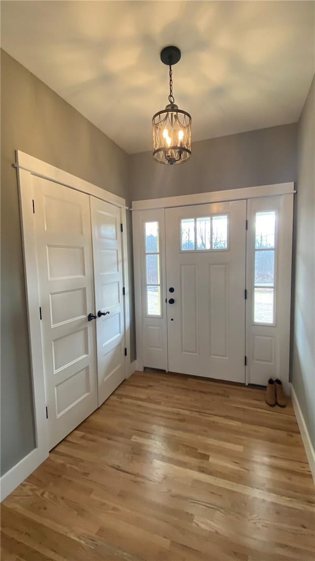 foyer with hardwood / wood-style floors and a chandelier