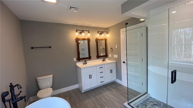 bathroom featuring hardwood / wood-style floors, vanity, toilet, and walk in shower