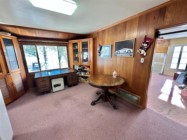 home office with light colored carpet, crown molding, and wooden walls