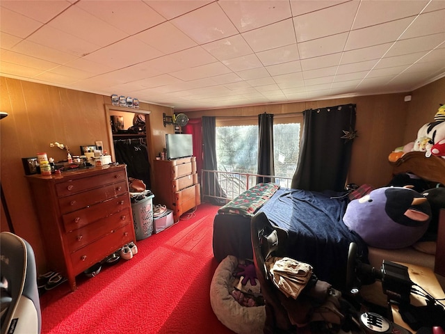 carpeted bedroom with wooden walls