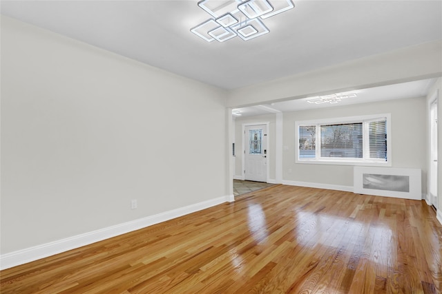 unfurnished living room featuring radiator and wood-type flooring