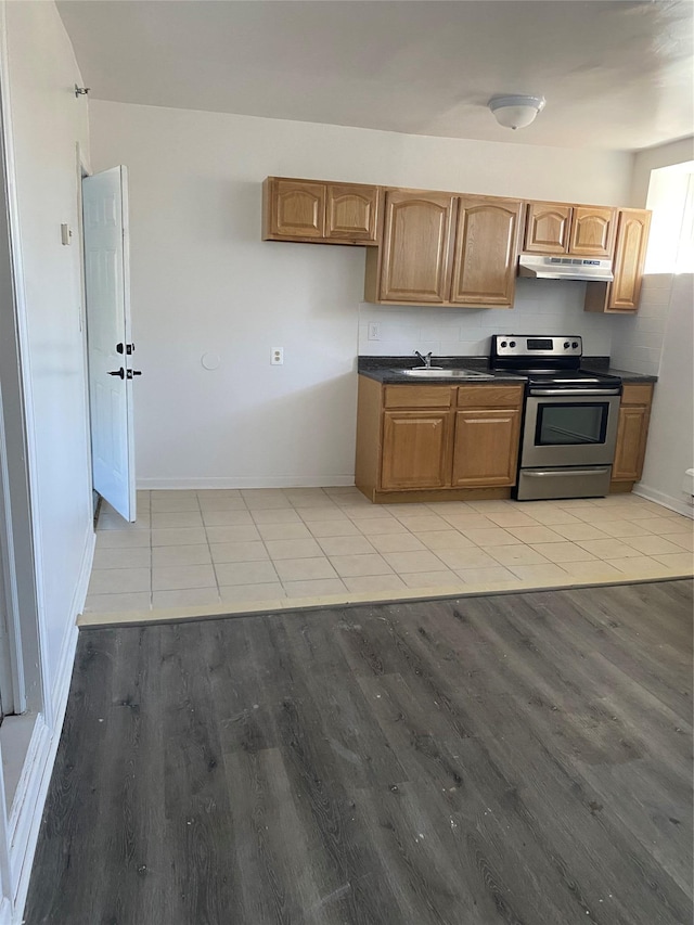 kitchen with electric range, light wood-type flooring, and sink