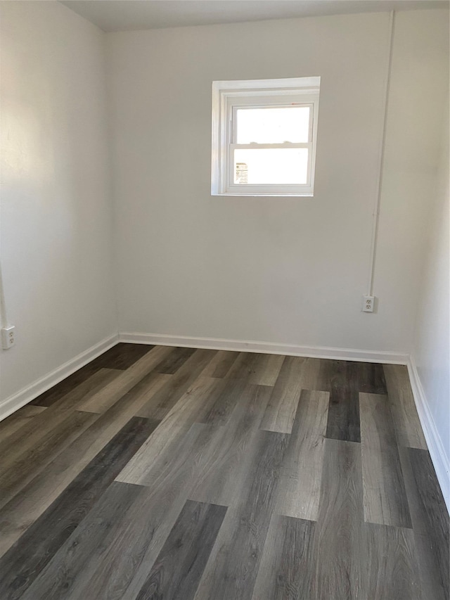 unfurnished room with dark hardwood / wood-style flooring