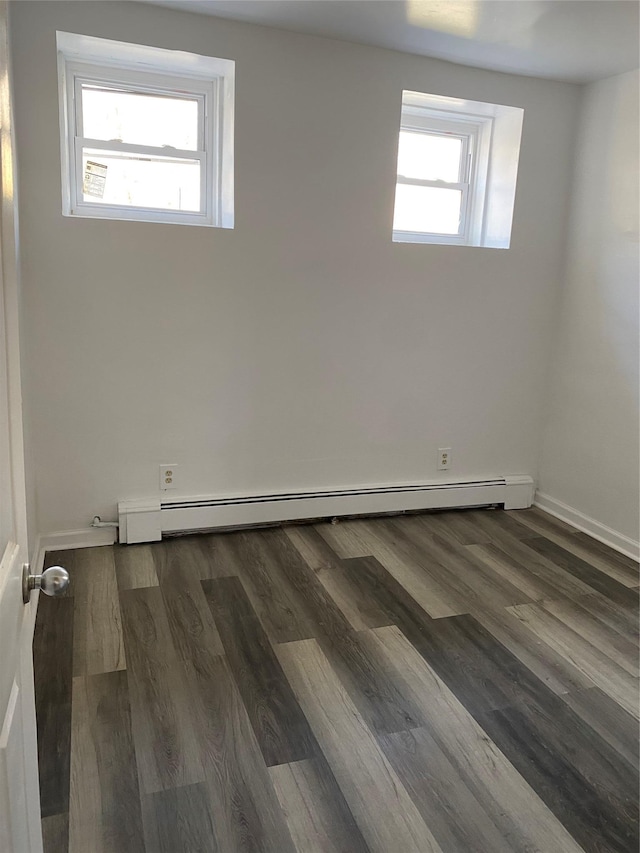 empty room with plenty of natural light, dark hardwood / wood-style flooring, and a baseboard radiator