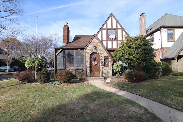 english style home with a sunroom and a front yard