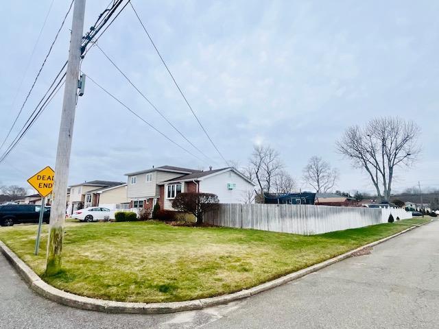 view of home's exterior with a water view and a yard