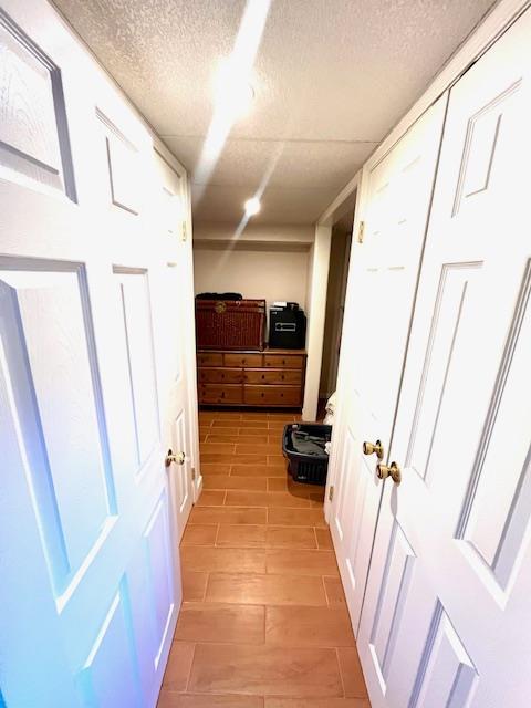 hallway featuring a textured ceiling and light wood-type flooring