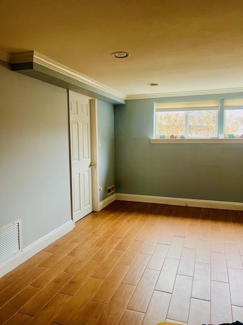 spare room with hardwood / wood-style flooring and ornamental molding