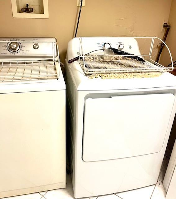 laundry area featuring washer and clothes dryer and light tile patterned flooring