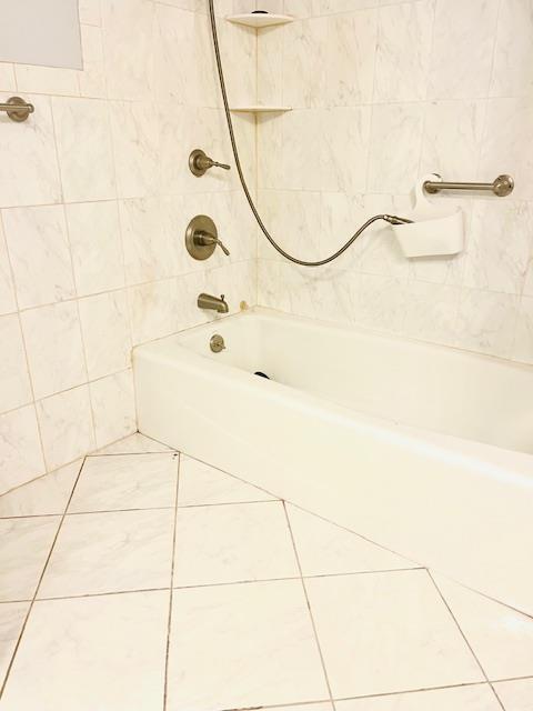 bathroom with tile patterned floors and tiled shower / bath