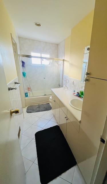 bathroom with tile patterned flooring, tiled shower / bath combo, and vanity